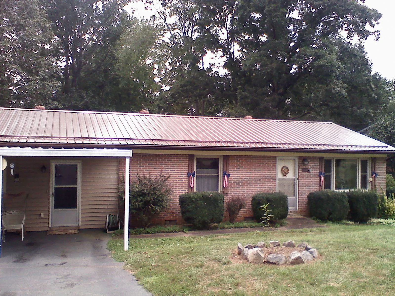 Bronze metal roof and carport on a brick ranch home — Roof Repair work by our crew in Aquasco